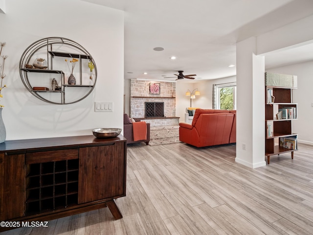 5825 N Camino Miraval Dr, Tucson, AZ 85718 - living room with ceiling fan, recessed lighting, wood finished floors, a large fireplace, and baseboards