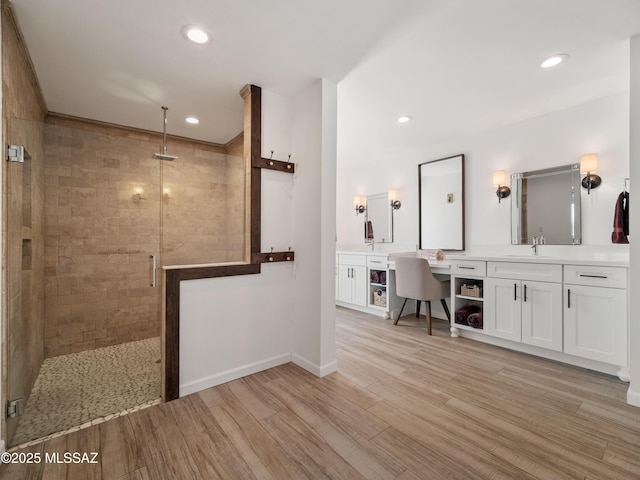 5825 N Camino Miraval Dr, Tucson, AZ 85718 - bathroom featuring a stall shower, wood finished floors, double vanity, recessed lighting, and baseboards