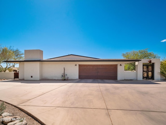 5825 N Camino Miraval Dr, Tucson, AZ 85718 - view of front of home featuring an attached garage, concrete driveway, and stucco siding