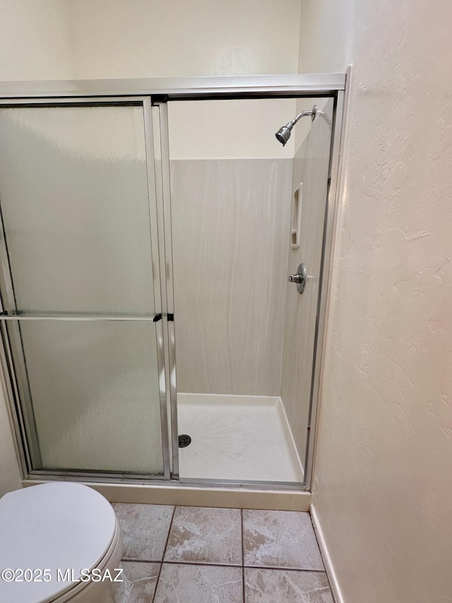 1989 N Camino Agrios, Tucson, AZ 85715 - bathroom with a textured wall, a stall shower, toilet, and tile patterned flooring