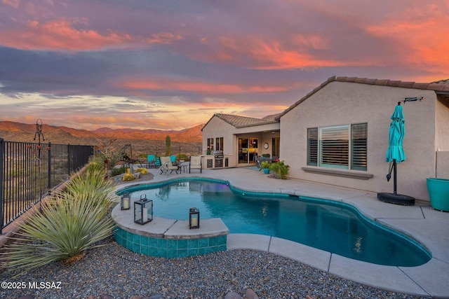 66450 E Sundance Pl, Saddlebrooke, AZ 85739 - pool at dusk with a patio area, a fenced backyard, and a mountain view