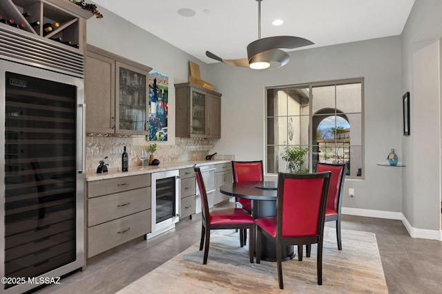 66450 E Sundance Pl, Saddlebrooke, AZ 85739 - tiled dining area with wine cooler, a bar, baseboards, and a ceiling fan