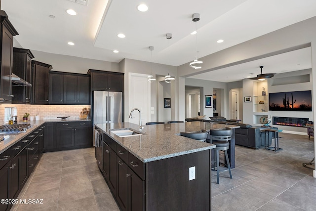 66450 E Sundance Pl, Saddlebrooke, AZ 85739 - kitchen featuring a sink, open floor plan, appliances with stainless steel finishes, a large island with sink, and light stone countertops