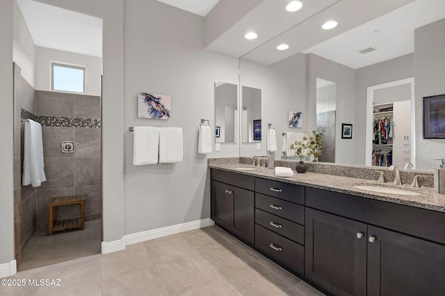 66450 E Sundance Pl, Saddlebrooke, AZ 85739 - bathroom with walk in shower, double vanity, baseboards, a walk in closet, and recessed lighting