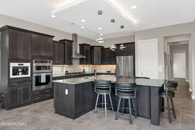 66450 E Sundance Pl, Saddlebrooke, AZ 85739 - kitchen featuring stainless steel appliances, wall chimney exhaust hood, a sink, backsplash, and a spacious island