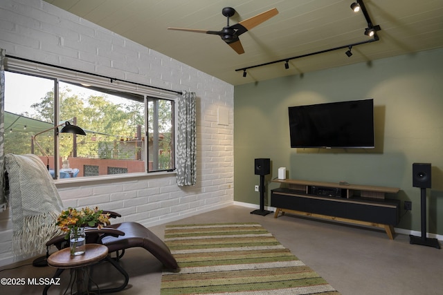 6714 E Topke St, Tucson, AZ 85715 - living area with track lighting, brick wall, baseboards, a ceiling fan, and concrete floors