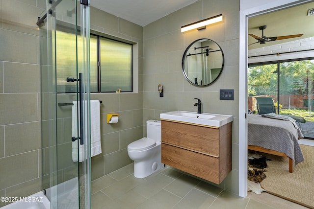 6714 E Topke St, Tucson, AZ 85715 - ensuite bathroom featuring tile walls, a ceiling fan, a shower stall, tile patterned flooring, and toilet