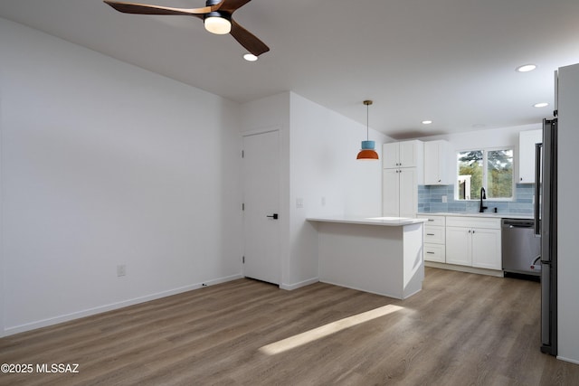 6714 E Topke St, Tucson, AZ 85715 - kitchen featuring stainless steel dishwasher, a sink, wood finished floors, decorative backsplash, and white cabinetry