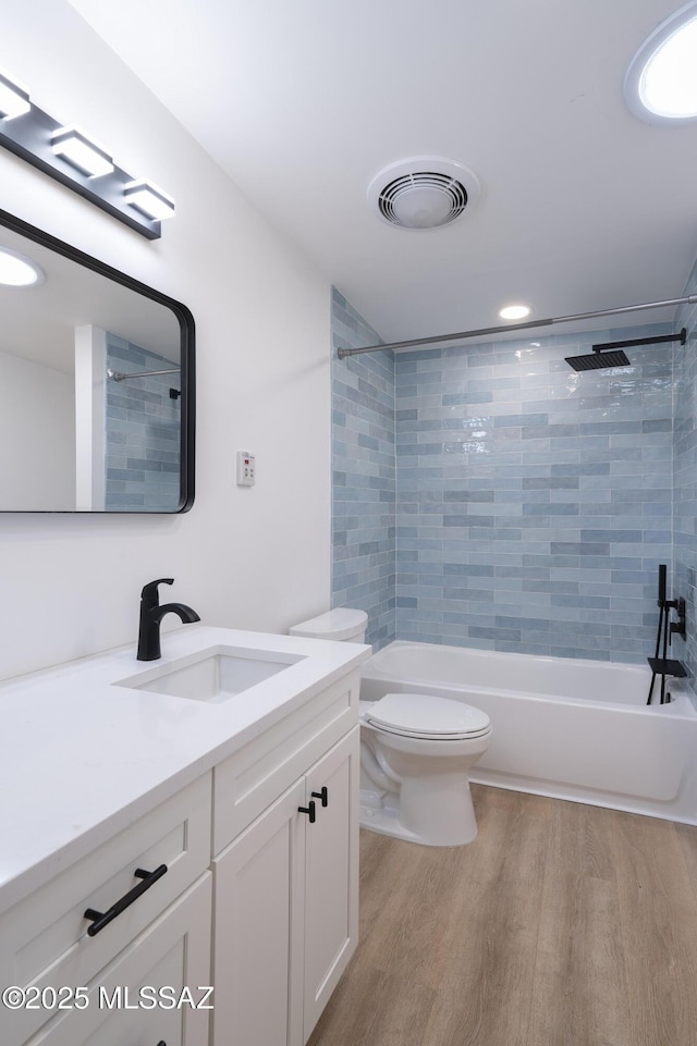 6714 E Topke St, Tucson, AZ 85715 - bathroom with wood finished floors, toilet, vanity, tub / shower combination, and recessed lighting