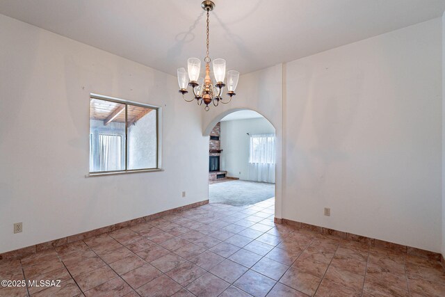 3531 W Goret Rd, Tucson, AZ 85745 - unfurnished room featuring arched walkways, a chandelier, and baseboards