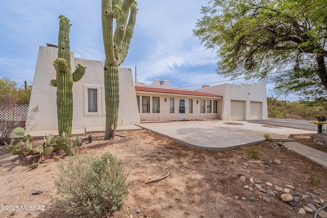 3531 W Goret Rd, Tucson, AZ 85745 - rear view of house with stucco siding, a patio area, a tile roof, and a garage