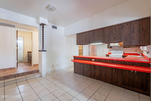 3531 W Goret Rd, Tucson, AZ 85745 - kitchen featuring white range with electric cooktop, a sink, dark brown cabinetry, and light tile patterned floors