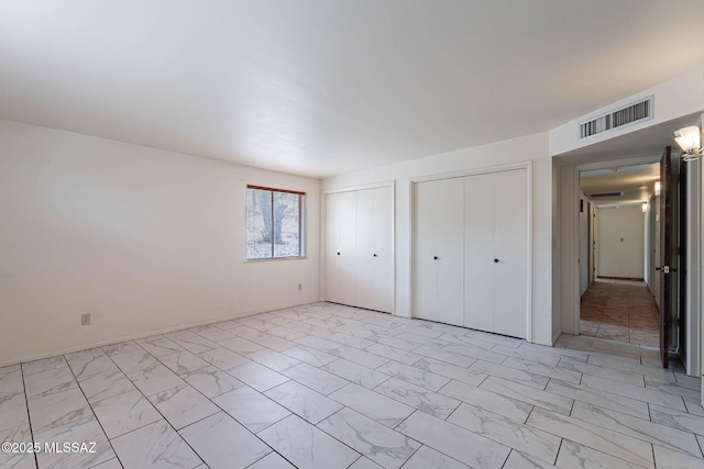 3531 W Goret Rd, Tucson, AZ 85745 - unfurnished bedroom with multiple closets and light marble finish flooring