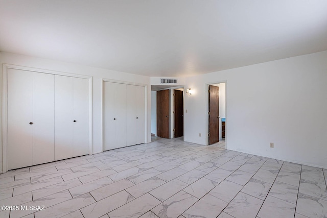3531 W Goret Rd, Tucson, AZ 85745 - unfurnished bedroom featuring multiple closets and light marble finish floors
