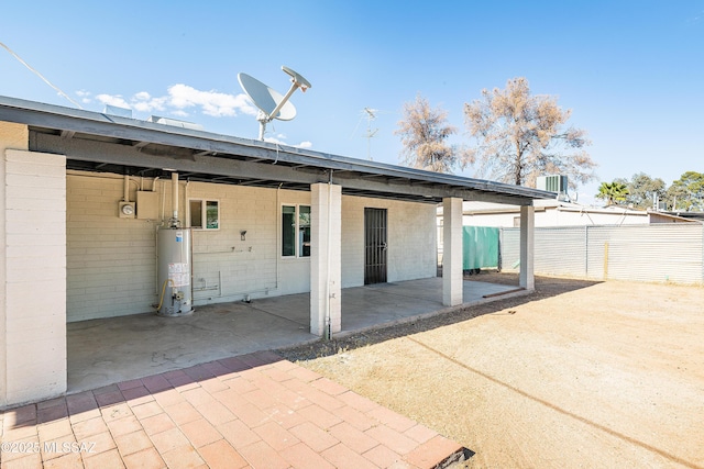 rear view of house featuring gas water heater, a patio, and fence