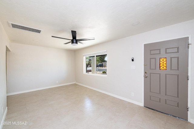 empty room featuring a ceiling fan and baseboards