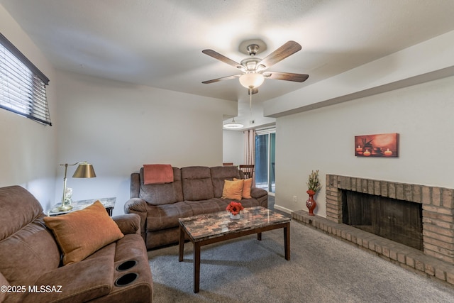 living area featuring ceiling fan, carpet floors, and a fireplace