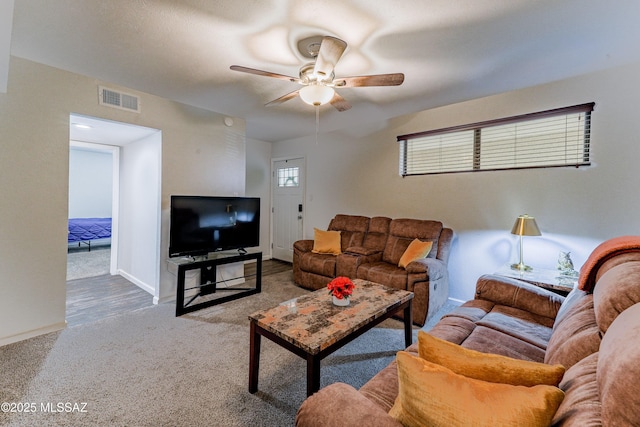 living area with ceiling fan, carpet flooring, and baseboards