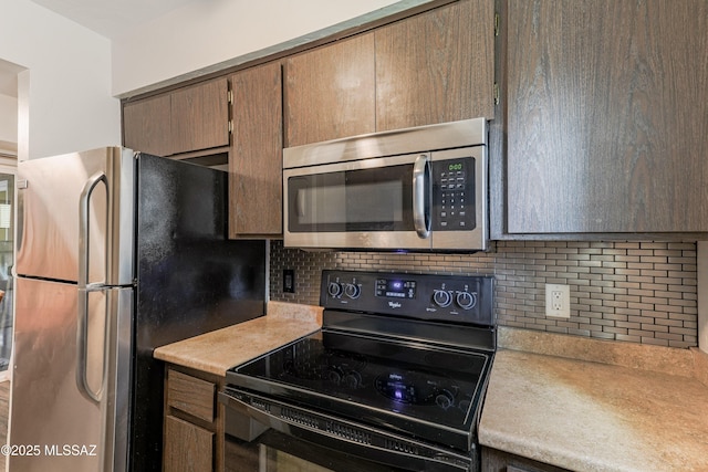 kitchen with appliances with stainless steel finishes, tasteful backsplash, and light countertops