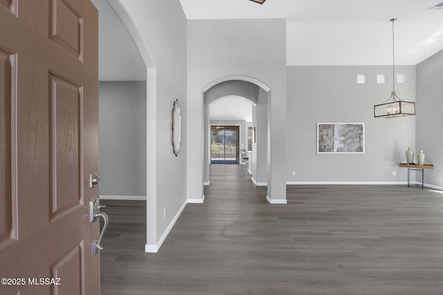 63370 E Whispering Tree Ln, Saddlebrooke, AZ 85739 - entrance foyer featuring arched walkways, dark wood-style floors, baseboards, and a chandelier