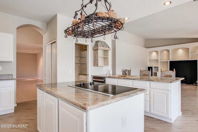 36359 S Wind Crest Dr, Saddlebrooke, AZ 85739 - kitchen with black electric cooktop, a center island, arched walkways, light wood-type flooring, and recessed lighting