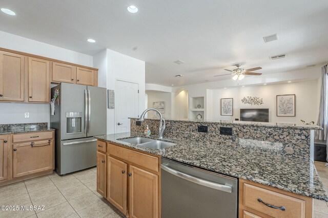 825 E Gunsight Mountain Pl, Sahuarita, AZ 85629 - kitchen featuring appliances with stainless steel finishes, a sink, ceiling fan, dark stone countertops, and a center island with sink