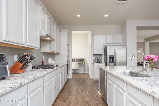 12493 N Blondin Dr, Marana, AZ 85653 - kitchen featuring appliances with stainless steel finishes, under cabinet range hood, a sink, white cabinetry, and backsplash