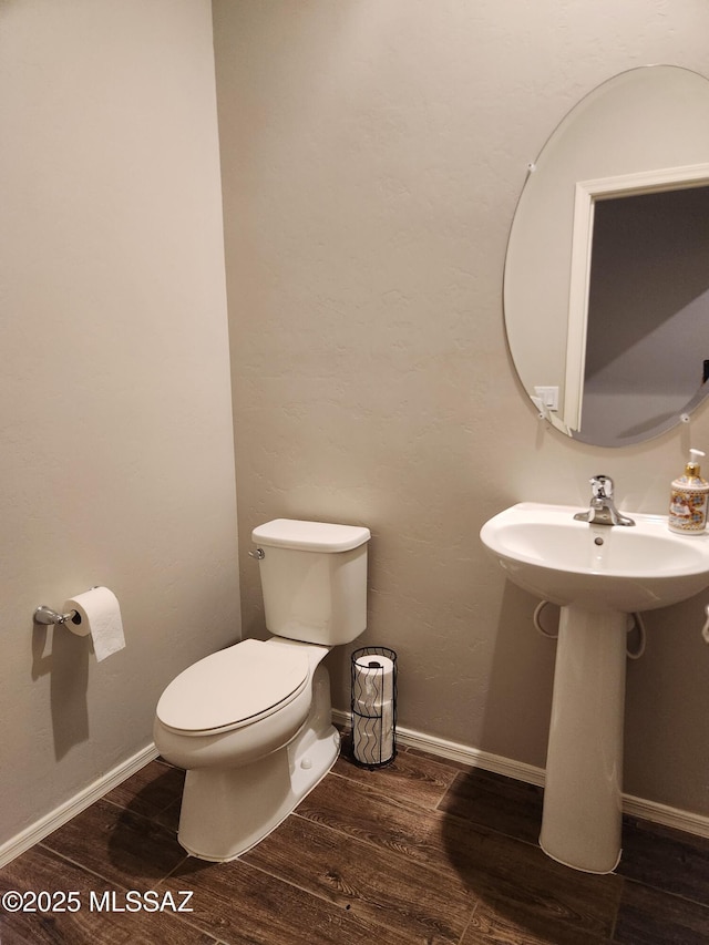 12493 N Blondin Dr, Marana, AZ 85653 - half bath with wood finished floors, toilet, a sink, and baseboards