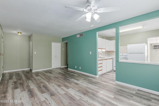 8150 E Broadway Blvd Unit H-107, Tucson, AZ 85710 - empty room with a ceiling fan, light wood finished floors, baseboards, and a sink