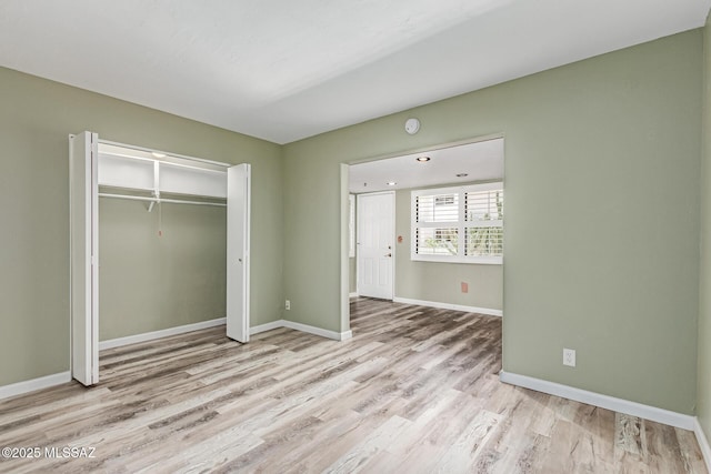8150 E Broadway Blvd Unit H-107, Tucson, AZ 85710 - unfurnished bedroom with light wood finished floors, baseboards, and a closet
