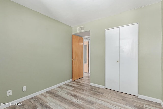 8150 E Broadway Blvd Unit H-107, Tucson, AZ 85710 - unfurnished bedroom featuring wood finished floors, baseboards, and a closet