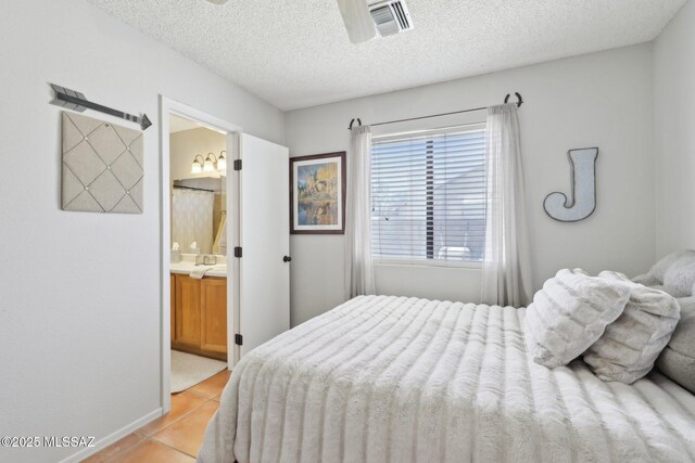 1861 W Sauvignon Dr, Tucson, AZ 85746 - bedroom with light tile patterned floors, a textured ceiling, ensuite bath, and baseboards