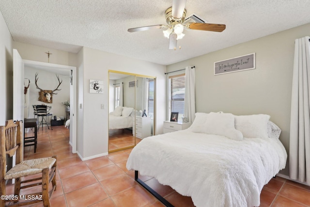1861 W Sauvignon Dr, Tucson, AZ 85746 - bedroom featuring light tile patterned floors, a closet, a textured ceiling, and ceiling fan