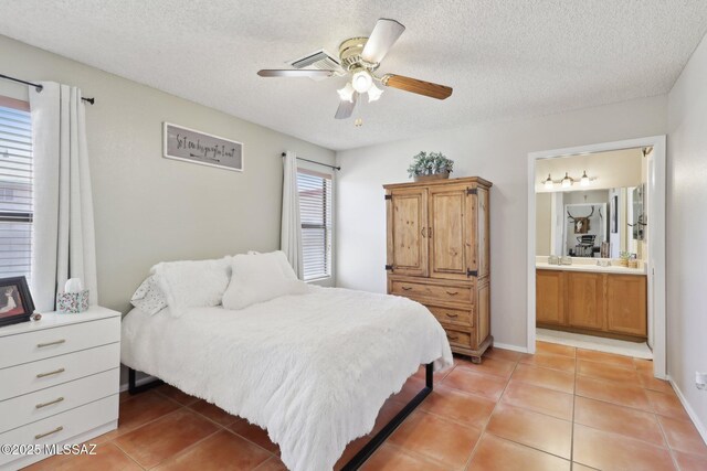 1861 W Sauvignon Dr, Tucson, AZ 85746 - bedroom with light tile patterned floors, a textured ceiling, ensuite bath, and a ceiling fan