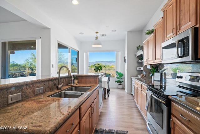 9451 S Via Bandera, Vail, AZ 85641 - kitchen with stainless steel appliances, a sink, light wood-style flooring, dark stone countertops, and recessed lighting