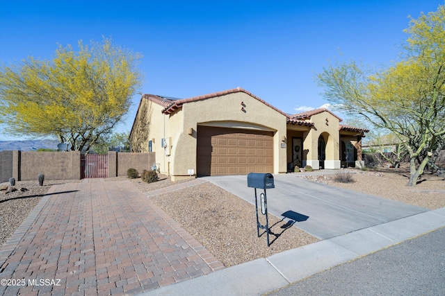 9451 S Via Bandera, Vail, AZ 85641 - mediterranean / spanish house featuring a gate, driveway, a garage, stucco siding, and fence