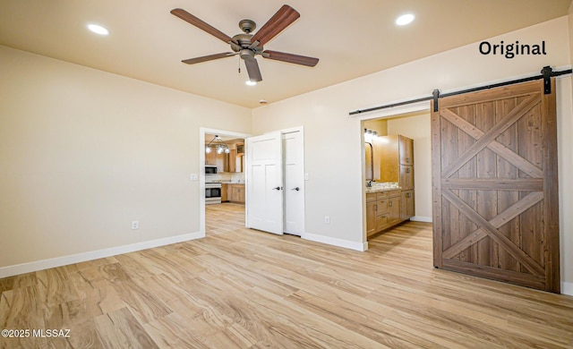 352 W Lee Trl, Safford, AZ 85546 - unfurnished bedroom with a barn door, connected bathroom, baseboards, recessed lighting, and light wood-style flooring