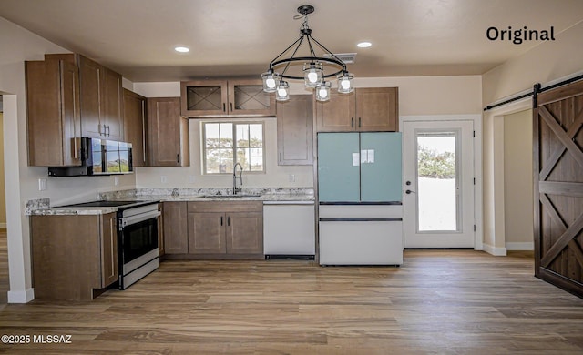 352 W Lee Trl, Safford, AZ 85546 - kitchen featuring white appliances, a sink, a barn door, light wood-style floors, and baseboards