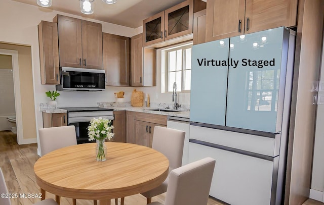 352 W Lee Trl, Safford, AZ 85546 - kitchen with stainless steel electric range oven, a sink, light wood-style floors, glass insert cabinets, and baseboards