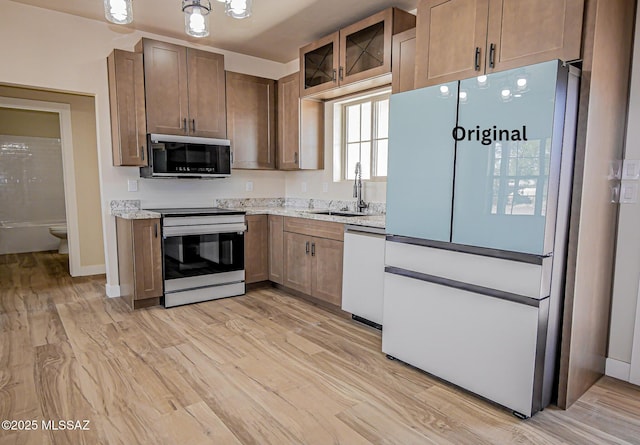 352 W Lee Trl, Safford, AZ 85546 - kitchen featuring white appliances, a sink, light wood-type flooring, glass insert cabinets, and light stone countertops