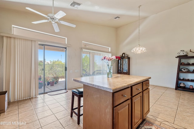 1797 W Naranja Dr, Oro Valley, AZ 85737 - kitchen featuring a towering ceiling, brown cabinets, light tile patterned floors, a kitchen breakfast bar, and light countertops