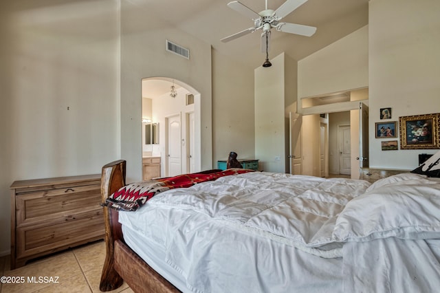 1797 W Naranja Dr, Oro Valley, AZ 85737 - bedroom with high vaulted ceiling, arched walkways, light tile patterned floors, ceiling fan, and ensuite bath