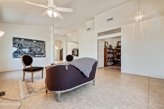 1797 W Naranja Dr, Oro Valley, AZ 85737 - living room featuring light tile patterned floors, arched walkways, a ceiling fan, and a towering ceiling