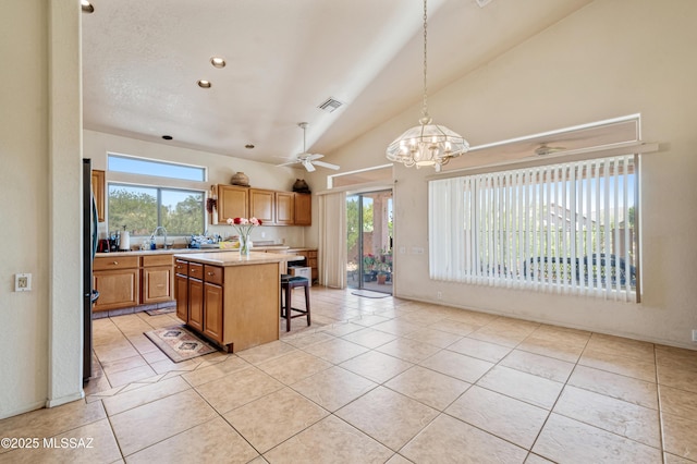 1797 W Naranja Dr, Oro Valley, AZ 85737 - kitchen with light countertops, a breakfast bar area, light tile patterned floors, healthy amount of natural light, and high vaulted ceiling