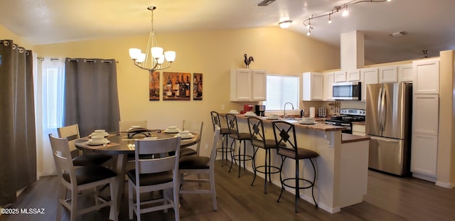 1732 W Pineriver Pl, Tucson, AZ 85746 - dining room with lofted ceiling, dark wood-style flooring, and a chandelier