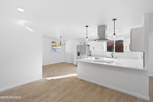 5011 E Scarlett St, Tucson, AZ 85711 - kitchen featuring island exhaust hood, stainless steel fridge, a sink, light countertops, and light wood-type flooring