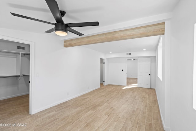 5011 E Scarlett St, Tucson, AZ 85711 - unfurnished bedroom with a walk in closet, light wood-style floors, baseboards, recessed lighting, and beamed ceiling