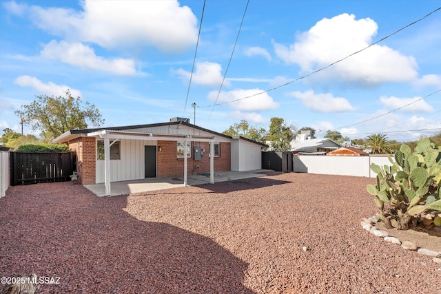 5011 E Scarlett St, Tucson, AZ 85711 - rear view of house featuring board and batten siding, a patio, a fenced backyard, and brick siding
