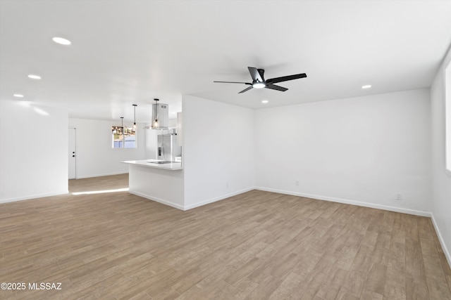 5011 E Scarlett St, Tucson, AZ 85711 - unfurnished living room featuring ceiling fan, recessed lighting, a chandelier, light wood-style flooring, and baseboards