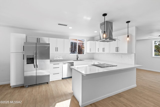 5011 E Scarlett St, Tucson, AZ 85711 - kitchen with stainless steel appliances, island exhaust hood, a sink, a peninsula, and backsplash